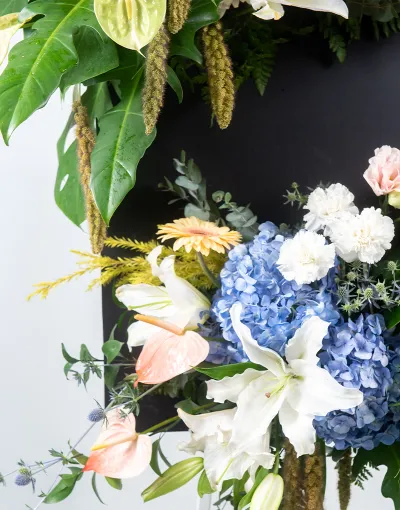 พวงหรีดดอกไม้สดทรงกลมโทนม่วงชมพูขาว ประดับลิลลี่สีชมพูและพวงมาลัยดอกมะลิ